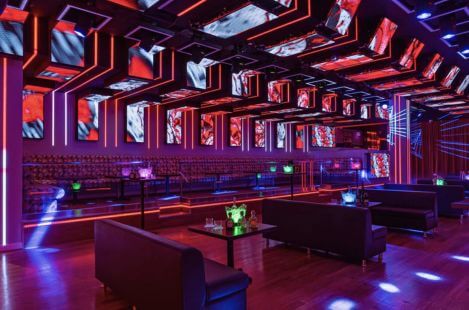 Luxury nightclub interior with LED ceiling panels, custom booth seating, and dynamic lighting design