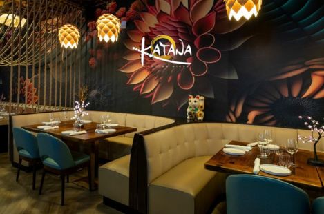 Elegant Japanese restaurant interior featuring curved booth seating, decorative lighting, and contemporary Asian design elements