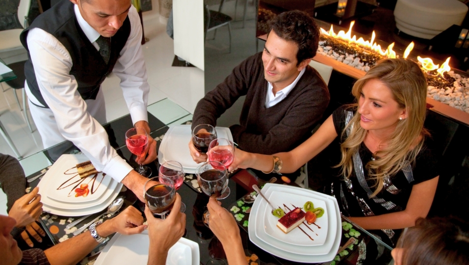 Server taking orders from guests at a casual dining restaurant — labor is the single largest operating cost for restaurant operators, representing 87% of controllable monthly costs