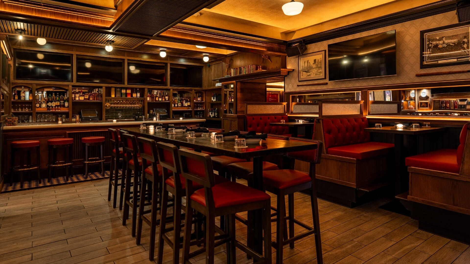 Central Park Tavern in Midtown NYC featuring custom red booths, warm wood finishes, and a classic sports bar ambiance