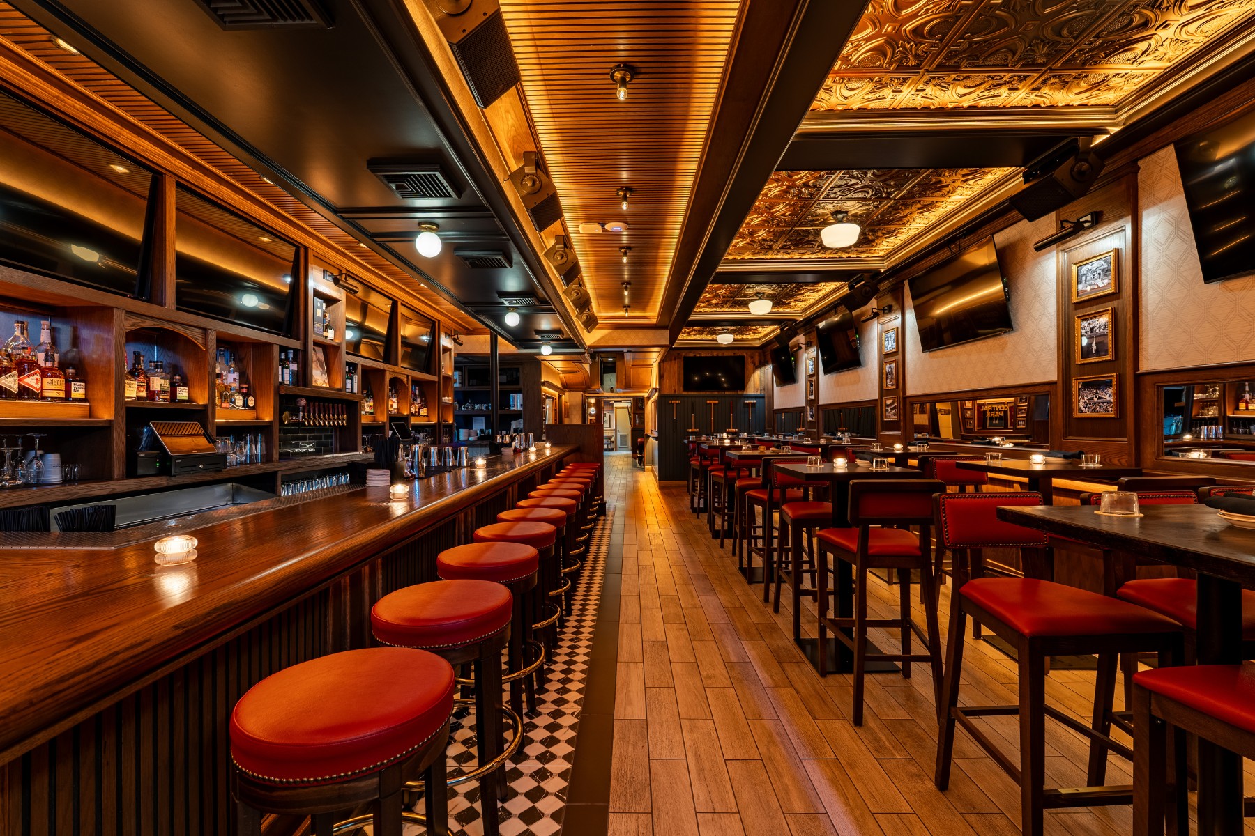 Commercial wood bar stools with natural finish at a warm restaurant bar interior showing grain texture and footrest detail