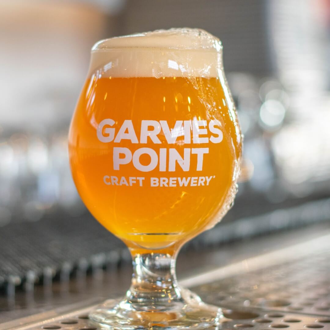 Light craft beer served in Garvies Point Brewery glass with foam head in industrial brewery setting