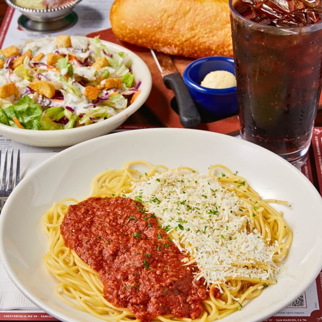 Classic spaghetti with meat sauce, fresh salad, and garlic bread at Old Spaghetti Factory