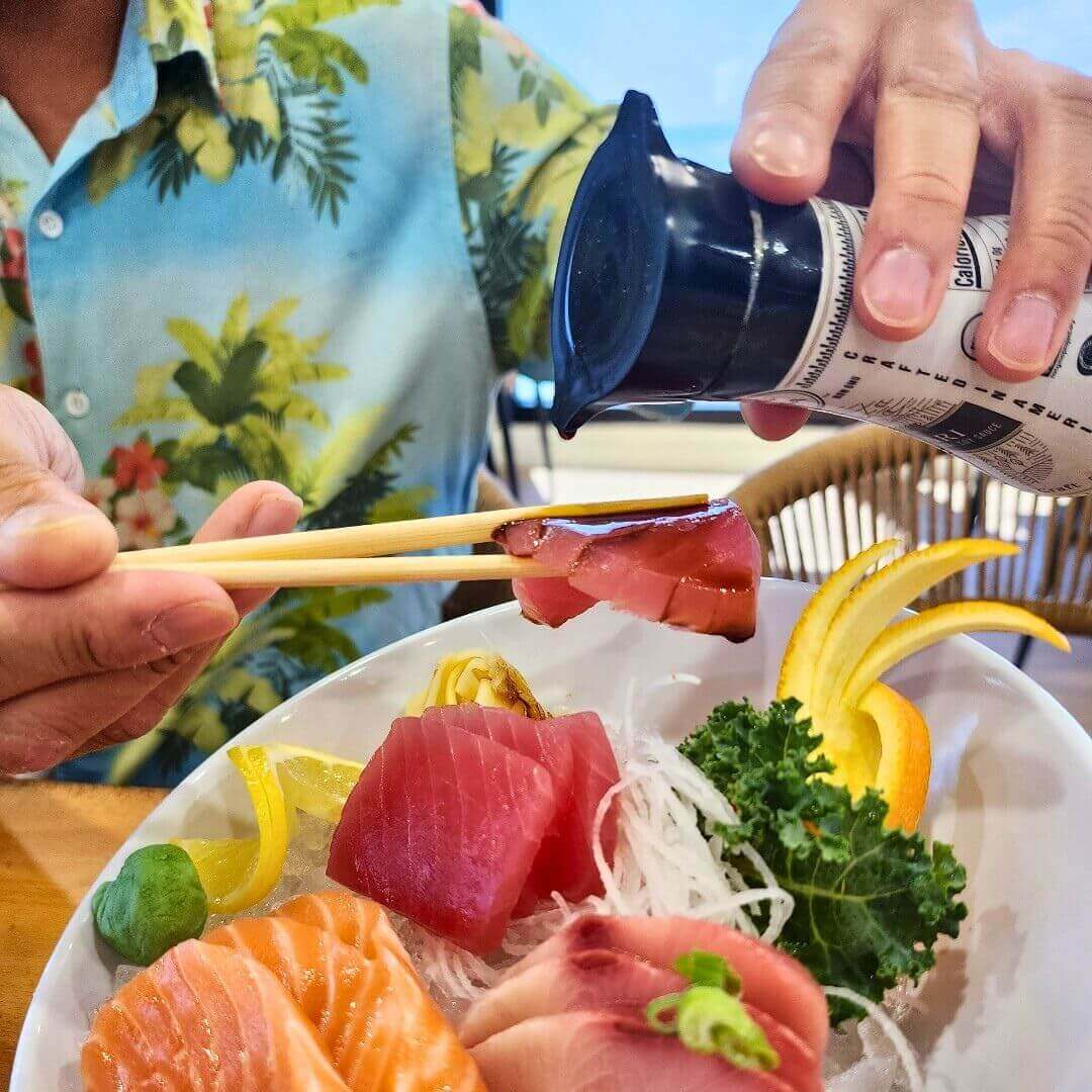 Premium sashimi platter at Pier 62's oceanfront restaurant featuring fresh tuna, salmon, and yellowtail with traditional garnishes